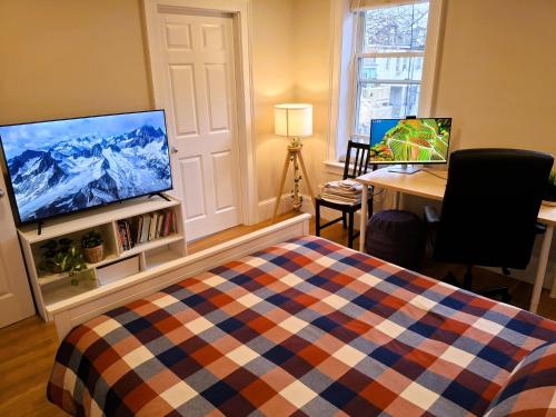 a bedroom with a bed and a flat screen tv at Homestay in South Boston in Boston