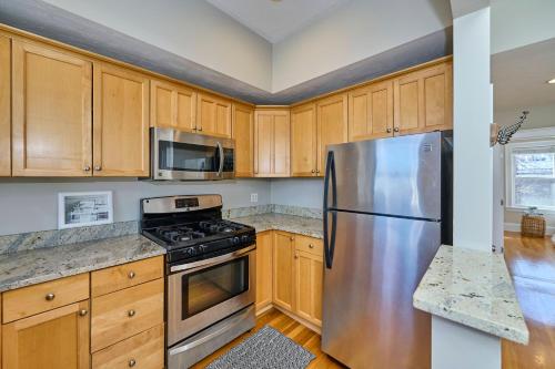 a kitchen with wooden cabinets and a stainless steel refrigerator at Homestay in South Boston in Boston