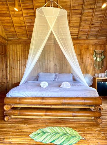 ein Bett in einem Zimmer mit Moskitonetz in der Unterkunft Phuree Hut in Ko Phayam