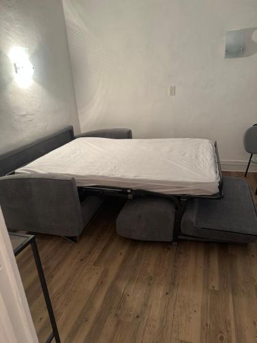 a bed in a small room with a wooden floor at Studio 17 1 chambre in La Bourboule