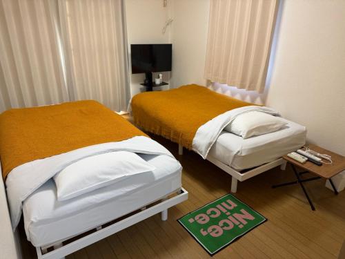 a bedroom with two beds and a sign on the floor at inn2nd101 in Kurashiki