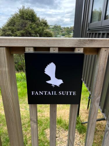 un panneau indiquant un terrain à louer sur une clôture en bois dans l'établissement Hidden Valley Waiheke, à Palm Beach