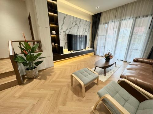 a living room with a couch and a tv at Naka Central Happy Home in Phuket city in Ban Rangeng