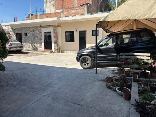 a black car parked in front of a house at 3 Acogedor apartamento en el corazón de Atlixco in Atlixco