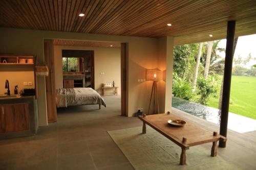 Un dormitorio con una cama y una mesa en una habitación. en Soma Beach House, en Balian