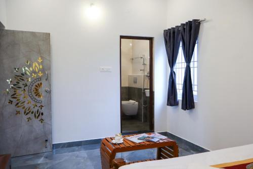 um banheiro com vaso sanitário e espelho em AK Residency em Yercaud