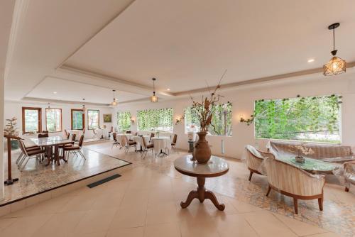 a large room with tables and chairs and windows at Urbanview De Ethnic Hotel Bandung by RedDoorz in Bandung
