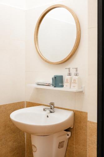 a bathroom with a sink and a mirror at Beyoung Hotel Dalat in Da Lat