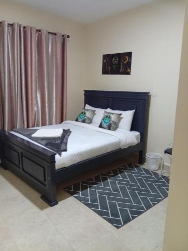 a bedroom with a bed with white sheets and pillows at JO kitengela deluxe Two and one bedroom in Kitengela 