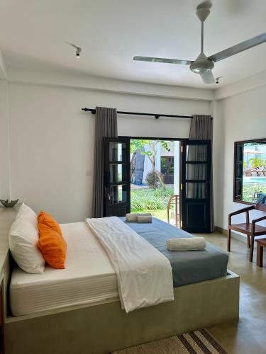 a bedroom with a large bed with orange pillows at Lum Residence in Ahangama