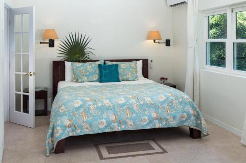 Un dormitorio con una cama con un edredón azul. en Karana Studio 2 - K2, en Long Bay Hills