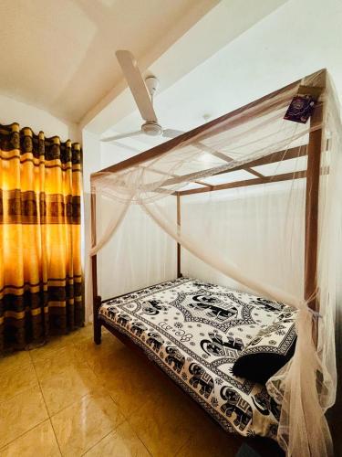 a bedroom with a bunk bed with a canopy at Nimsara Lodge in Hikkaduwa