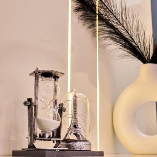 un vecchio orologio appoggiato su un tavolo accanto a un vaso di Purple Lavender Court a Ikoyi