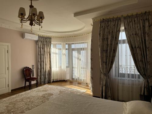 a bedroom with a bed with curtains and a chandelier at B&B Apartment Farhad Hospitality Solutions in Samarkand