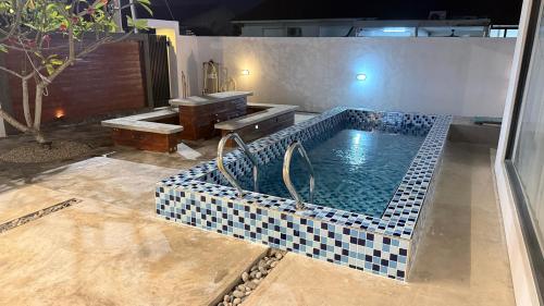 a bathroom with a pool with a table and a bench at Leisure29 Suites in Kuantan