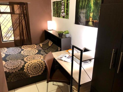 a bedroom with a bed and a desk and a table at Roomies Hostel - Roma in Mexico City