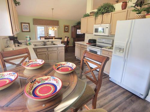 a kitchen with a table with chairs and a white refrigerator at Rocco's Retreat in Orlando
