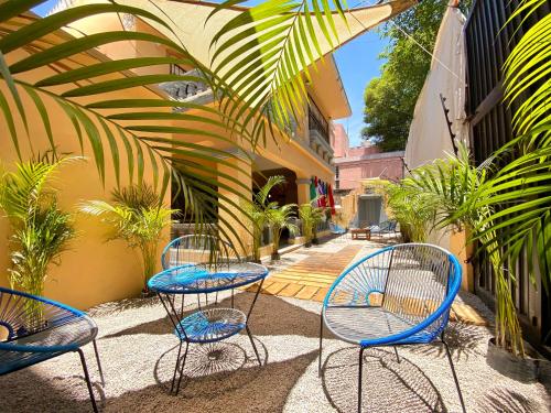 a group of chairs and tables in a courtyard at Roomies Hostel - Roma in Mexico City