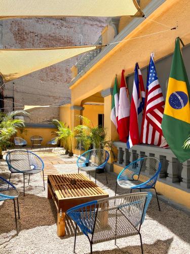 a group of tables and chairs with flags on a building at RMS Hostal - Insurgentes in Mexico City
