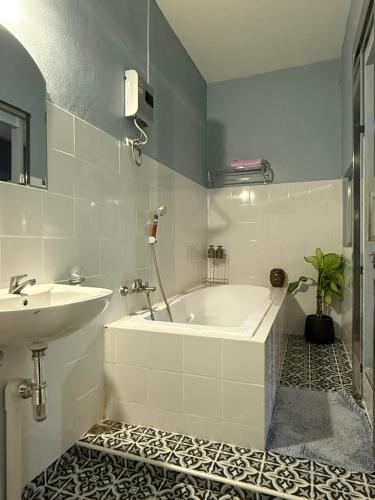 une salle de bain avec une baignoire et un lavabo dans l'établissement Mon Jam Cottage, à Chiang Mai