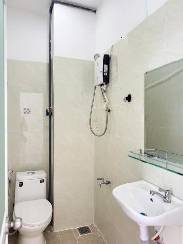 a bathroom with a toilet and a sink at Four P Home and Studio in Ho Chi Minh City