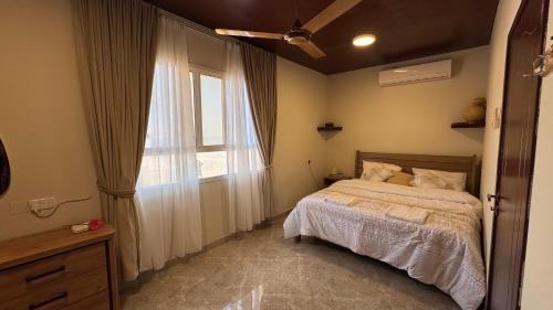 Un dormitorio con una cama y una ventana grande en Marsa wadi shab, en Ash Shāb