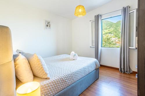 une chambre avec un lit et une grande fenêtre dans l'établissement Casa Miguel, à Machico