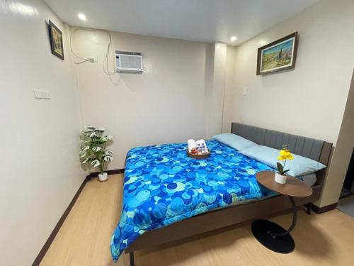 a small bedroom with a bed with a blue blanket at Potot Haven Dorm and Transient in Libmanan