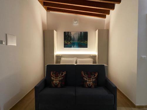 sala de estar con sofá azul y 2 almohadas en International Residence, en Tarvisio