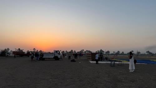 a group of people standing in a field at sunset at Mama Africa Apts & Studios in Luxor
