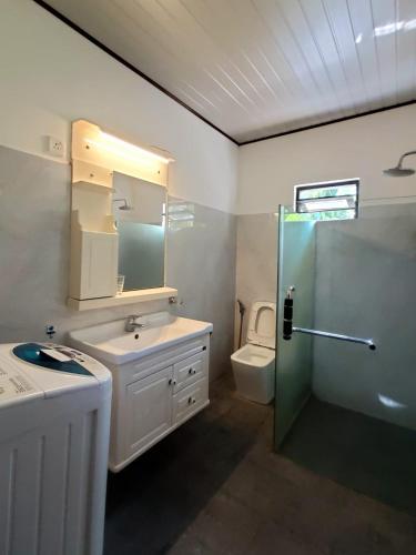 Un baño con lavabo, ducha e inodoro. en Jungle House, en Unawatuna
