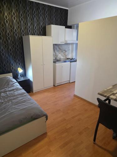 ein Schlafzimmer mit Bett, weißen Schränken und einem Tisch in der Unterkunft Studio 3 in Luxemburg (Stadt)