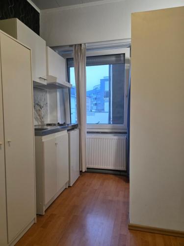 ein leerer Raum mit Fenster und Küche in der Unterkunft Studio 3 in Luxemburg (Stadt)