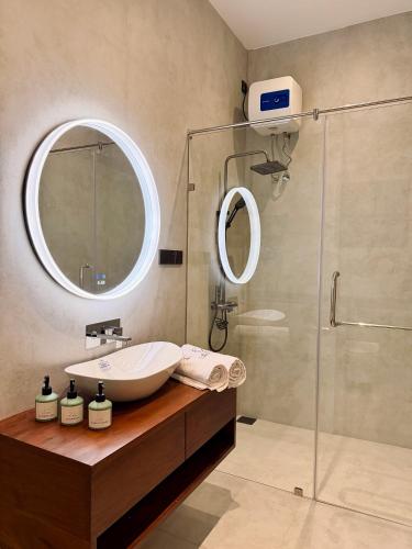 a bathroom with a sink and a glass shower at La Vizta Weligama in Weligama