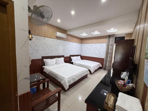 a hotel room with two beds and a television at Khách Sạn Long Khánh View Đẹp Đồng Nai in Long Khanh