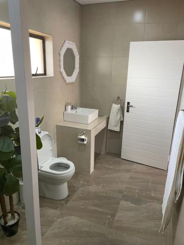 a bathroom with a toilet and a sink at Vakasha Lodge in Siphofaneni