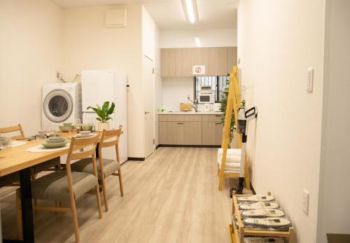 a kitchen and dining room with a table and a refrigerator at Osaka Shinsaibashi Dotonbori Courtyard Villa in Osaka