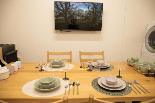 a dining room table with a television on the wall at Osaka Shinsaibashi Dotonbori Courtyard Villa in Osaka
