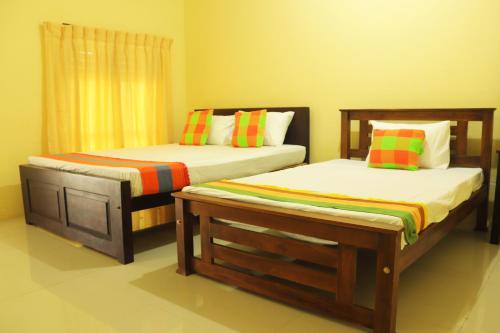 a bedroom with two beds and a window at Lishan Nature Resort - Kataragama in Gotamegama