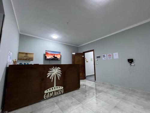 a room with a reception desk with a palm tree on it at Gamandy Hostel in Luxor