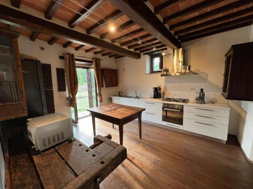 a kitchen with white cabinets and a wooden floor at Rustico Restaurato Sulle Colline Di Arezzo in San Polo
