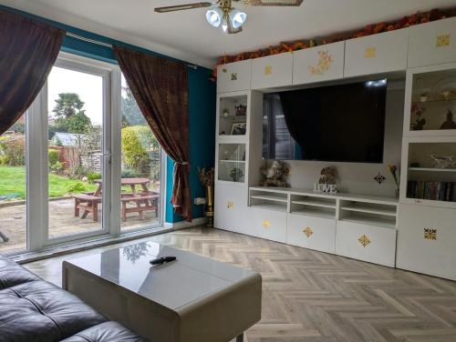 a living room with a couch and a tv at Large Central Lodge Near Heathrow Airport & London with Parking in Langley Station