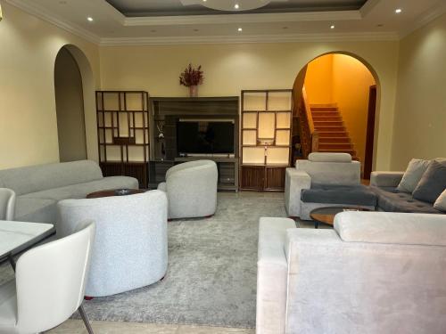 a living room with couches and chairs and a television at doge villa 2 in Dubai