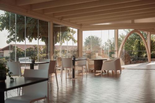 Un comedor con mesas y sillas y ventanas. en Terra di Vento, en Montecorvino Pugliano