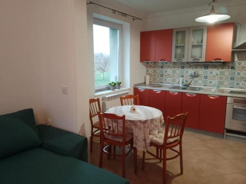 eine Küche mit einem Tisch, Stühlen und roten Schränken in der Unterkunft U bram Podbeskidzia in Ligota