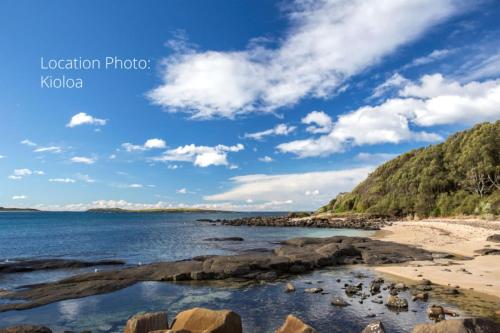 - une vue sur une plage avec des rochers dans l'eau dans l'établissement Retro Beach Cottage - classic surf getaway, à Kioloa