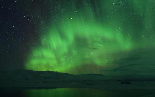 an aurora in the sky over a body of water at Hótel Laxá in Myvatn