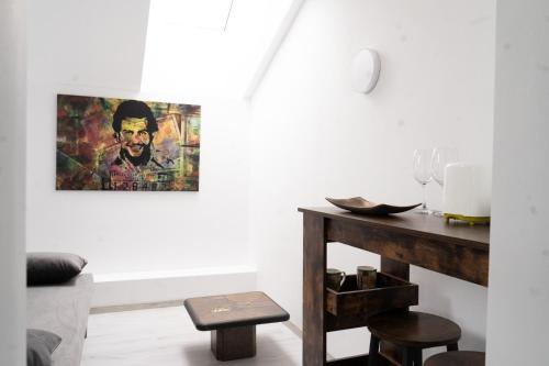 a living room with a table and a painting on the wall at CASA Don Lucio in Craiova