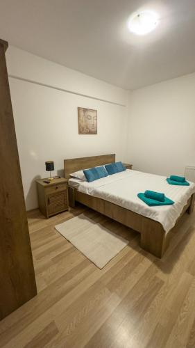 a bedroom with a large bed with blue pillows on it at Sweet Inn Apartment in Piteşti