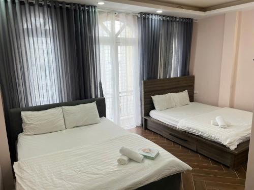 ein Schlafzimmer mit zwei Betten und einem Fenster in der Unterkunft LALA HOUSE - CĂN HỘ Đà Lạt in Khu Chi Lăng